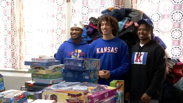 Los jugadores de fútbol americano de KU llevan abrigo de juguete a los niños necesitados de Lawrence
